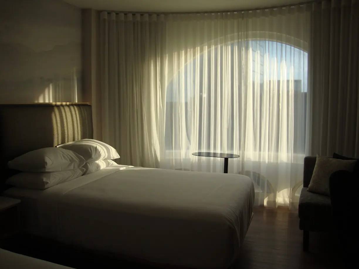 Habitació d'hotel amb cortines a mida filtrant la llum