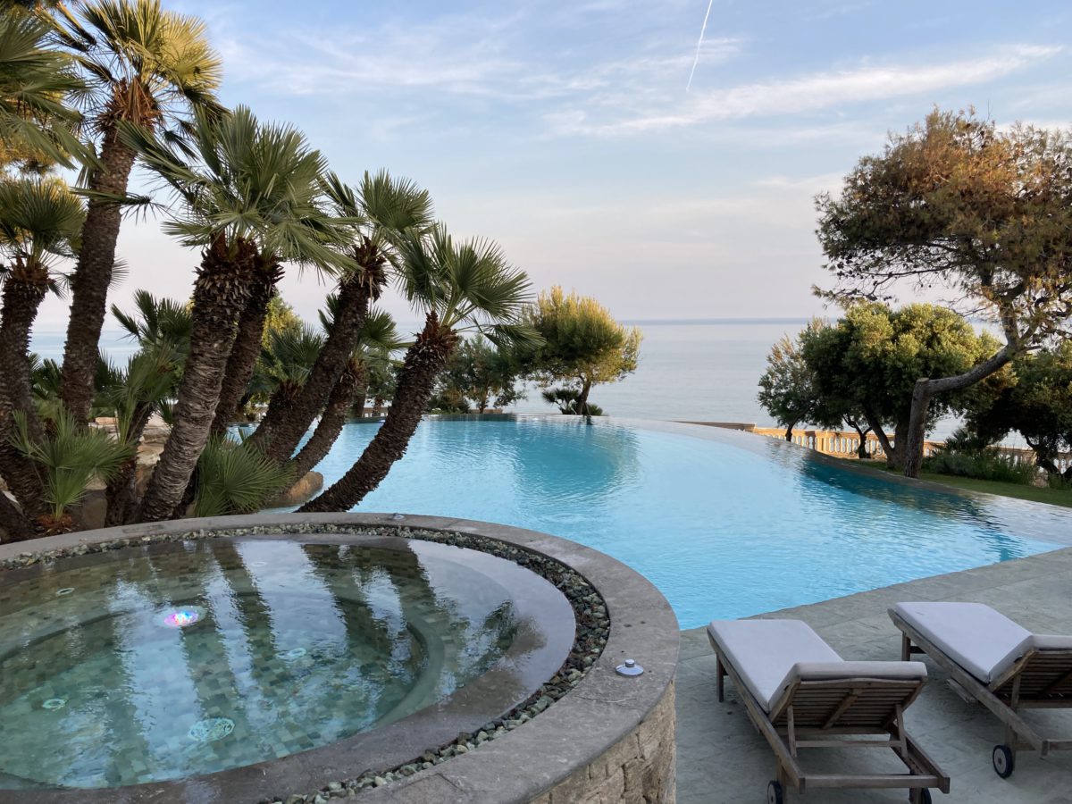 Piscina amb gandules encoixinades i vistes al mar