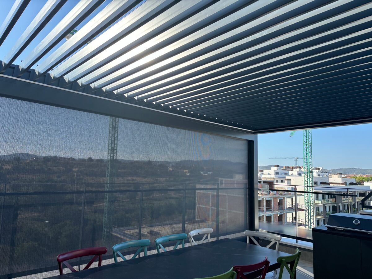 Pèrgola de lamel·les amb un tendal vertical de malla en una terrassa