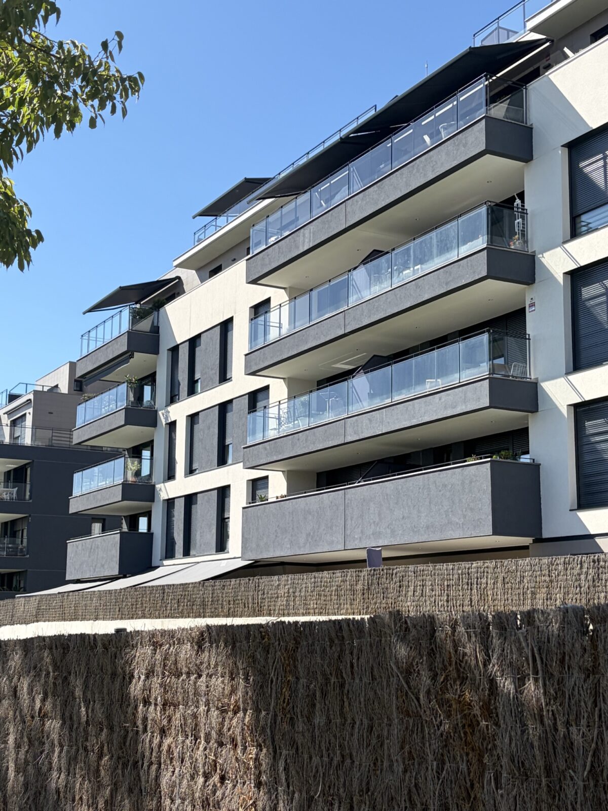 Façana d'un edifici de pisos amb tendals als balcons